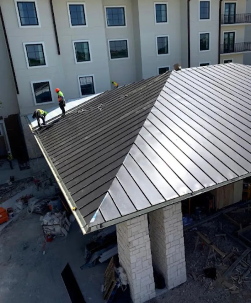 Crew installing standing seam metal roof panels on a commercial project in Landover